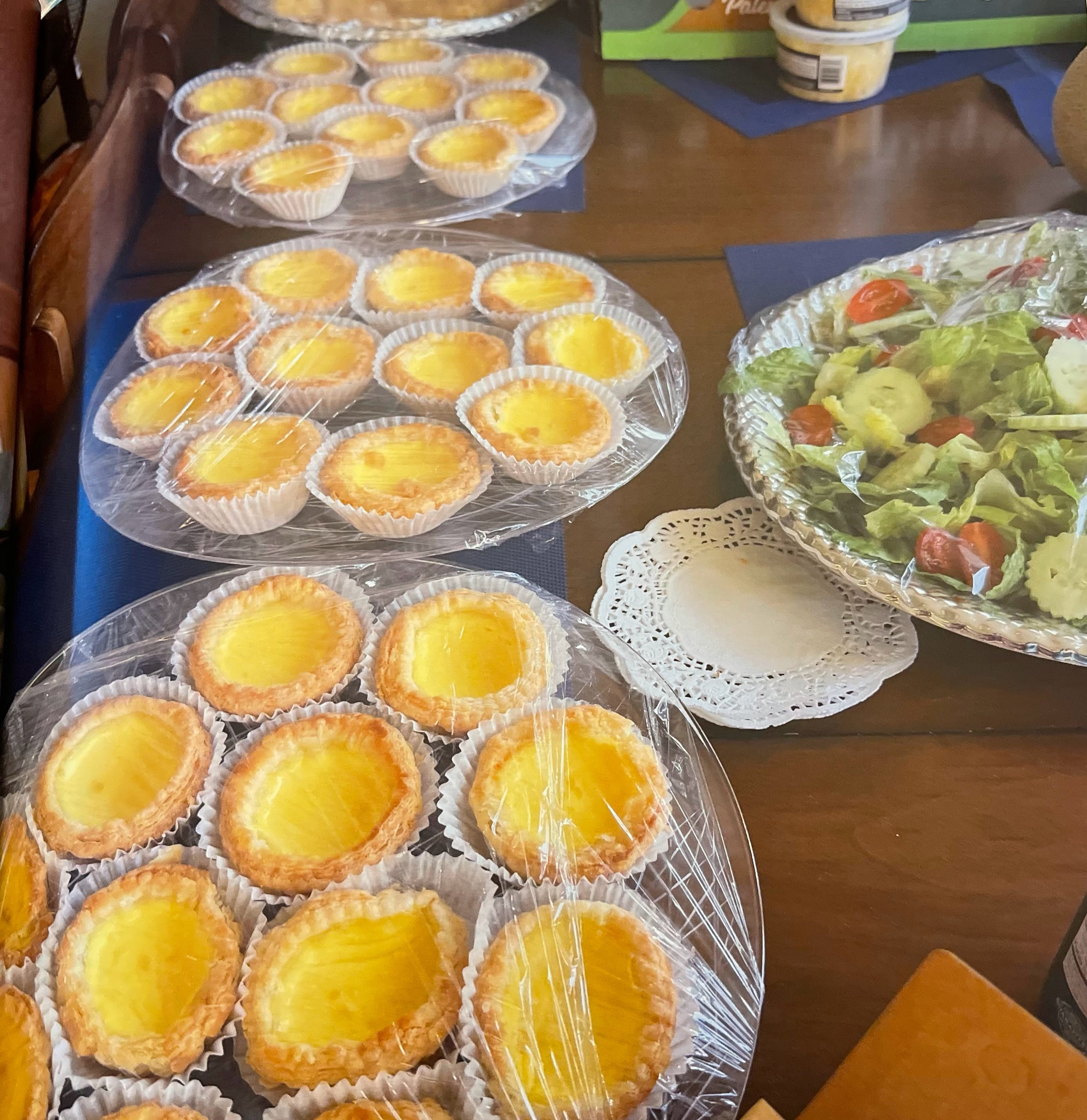 Dessert trays and a fresh salad prepared for guests