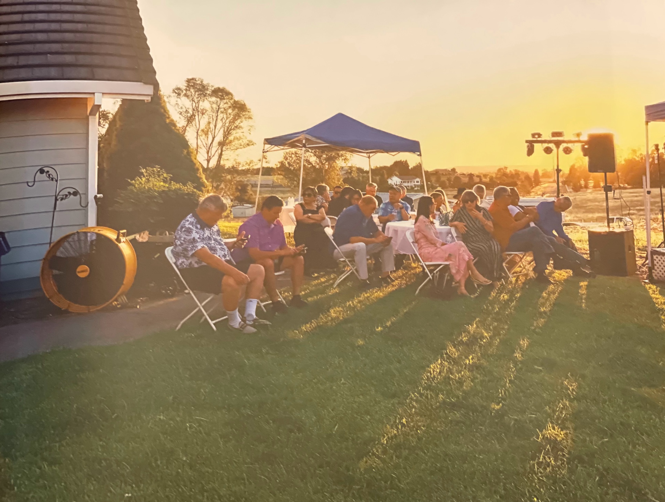 Guests seated together on the lawn during golden hour