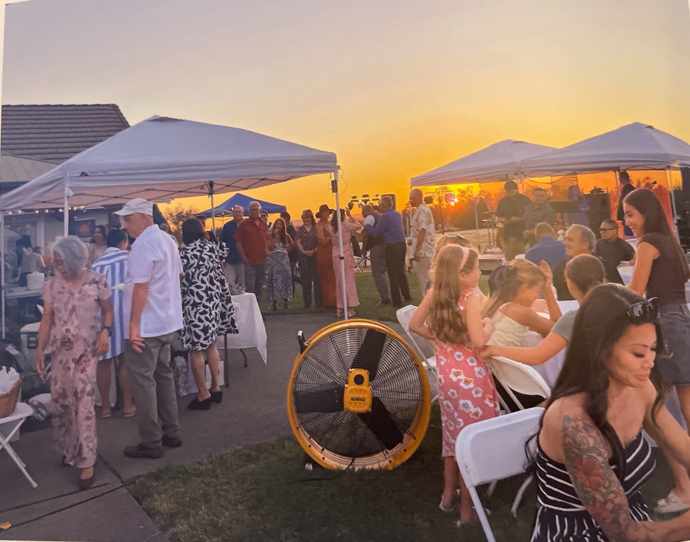 Guests gathering beneath white canopies at sunset at Amber Ranch